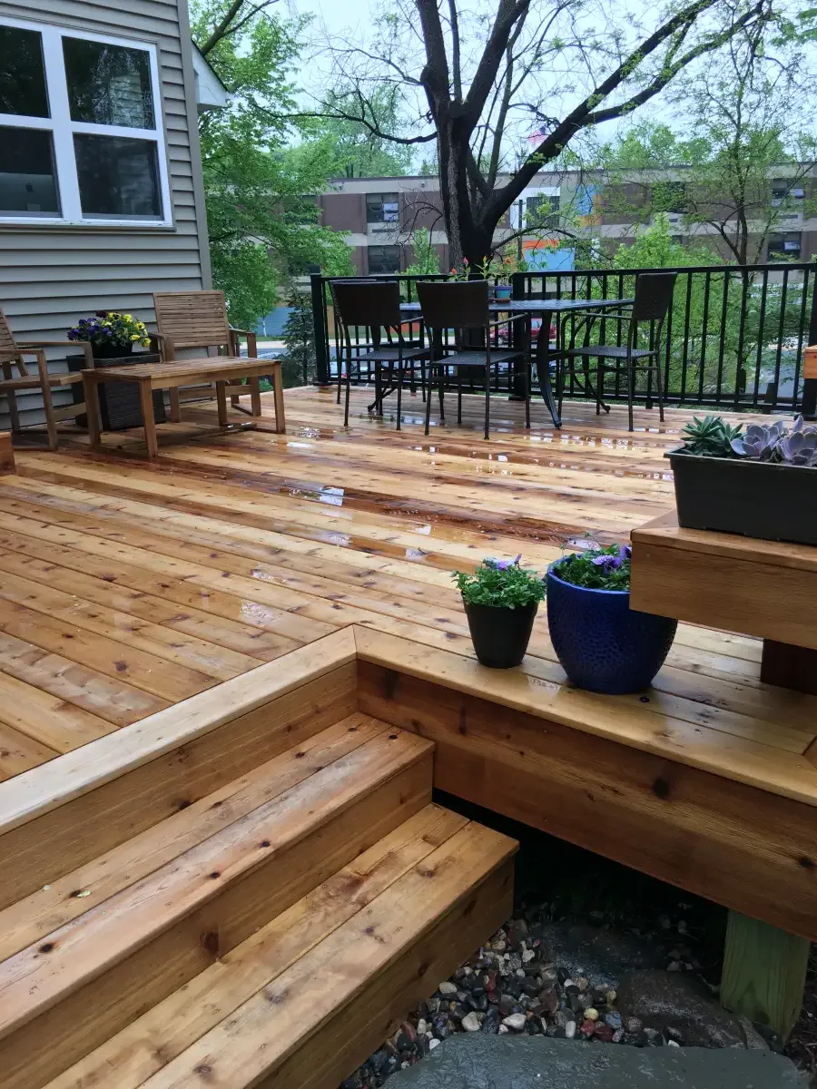 Wood deck with broad steps, outdoor seating and flower planters