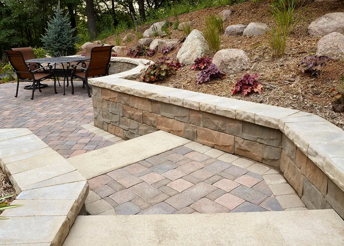 Curved low wall beside patio steps and a planted slope
